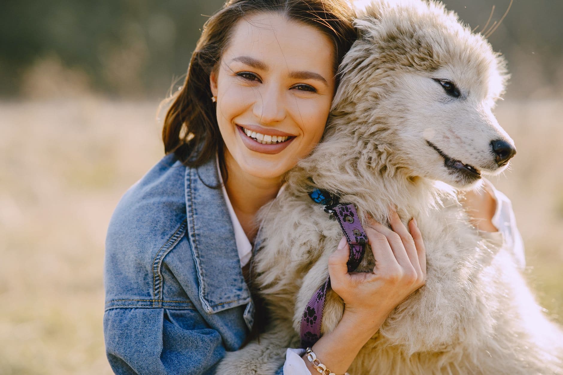 A joyful woman cheek to cheek with her happy dog